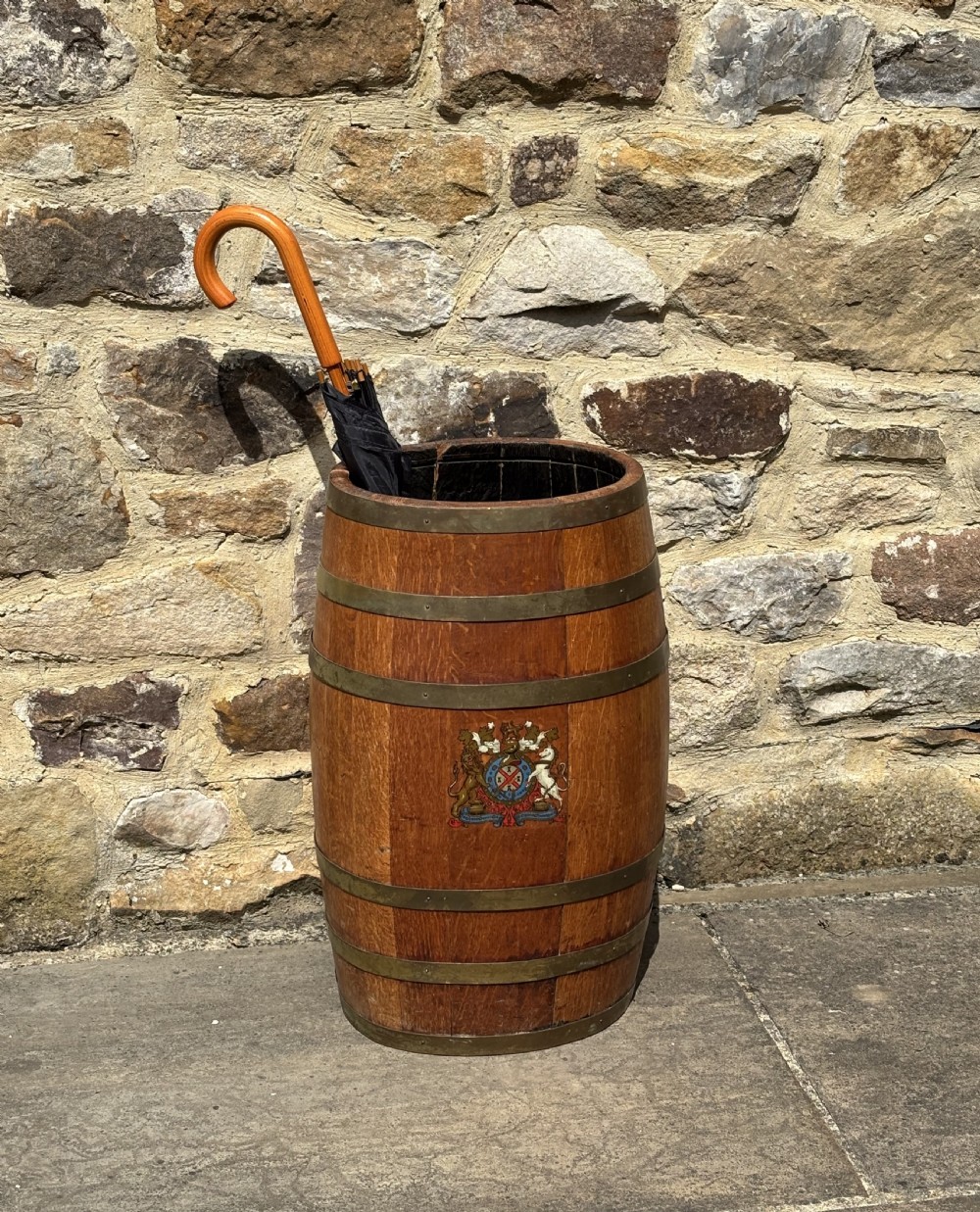 A 19th-century coopered oak barrel stick stand featuring brass hoops and a hand-painted crest on the front. View V