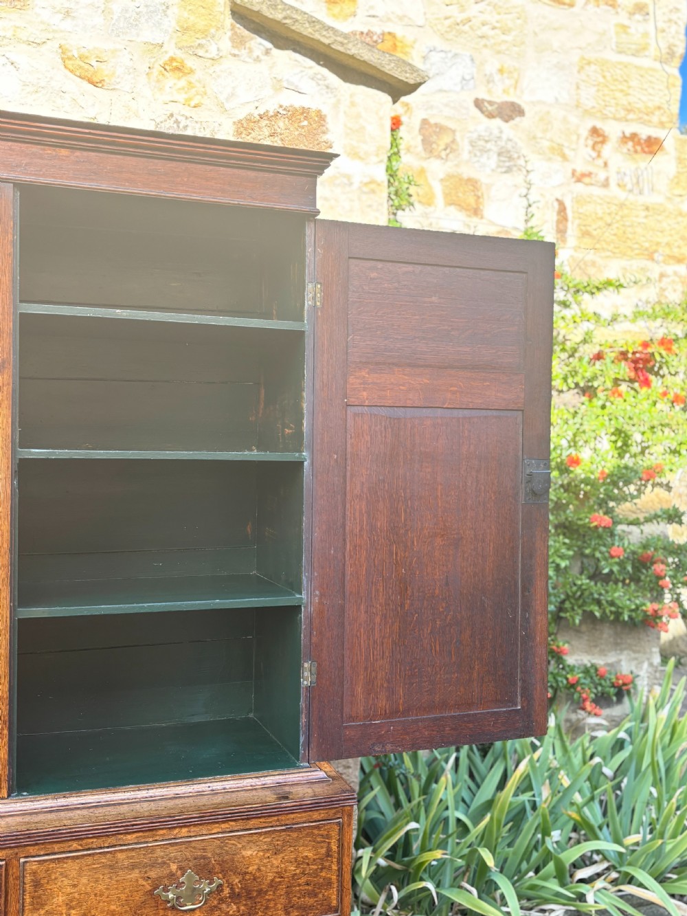 An 18th-century dark oak cupboard on chest featuring paneled upper doors, lower drawers with brass handles, and a moulded cornice. View VI