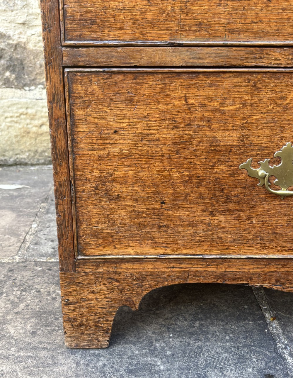 An 18th-century dark oak cupboard on chest featuring paneled upper doors, lower drawers with brass handles, and a moulded cornice. View IX