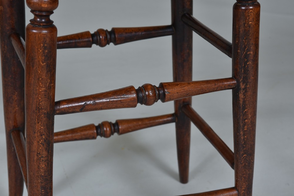A tall Regency mahogany stool featuring turned legs and stretchers with a dark brown leather upholstered seat trimmed with brass studs. View III