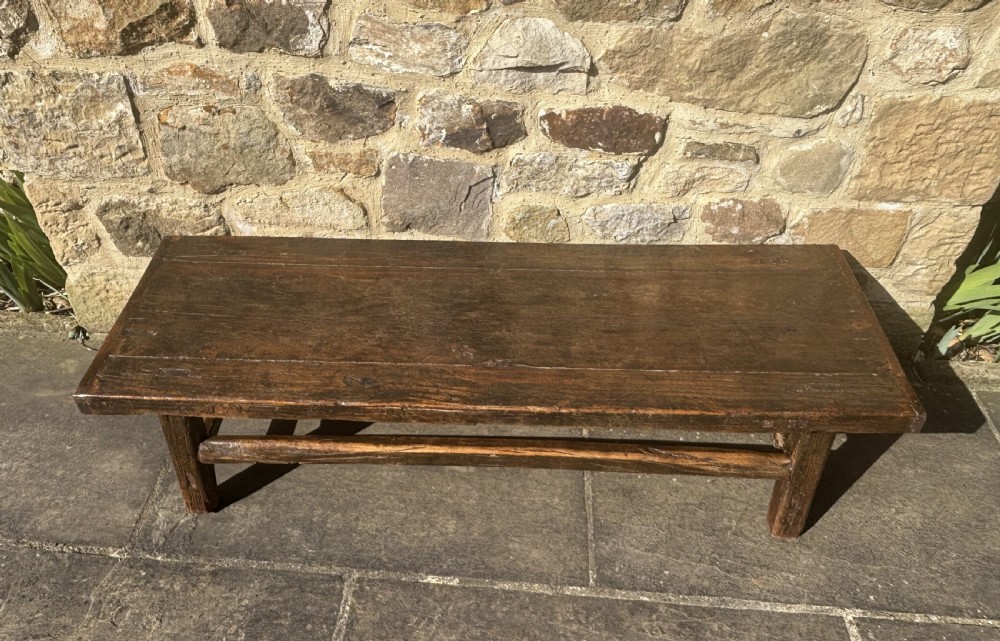 An antique low rectangular coffee table crafted from dark patinated elm wood with thick legs and sturdy stretchers. View II