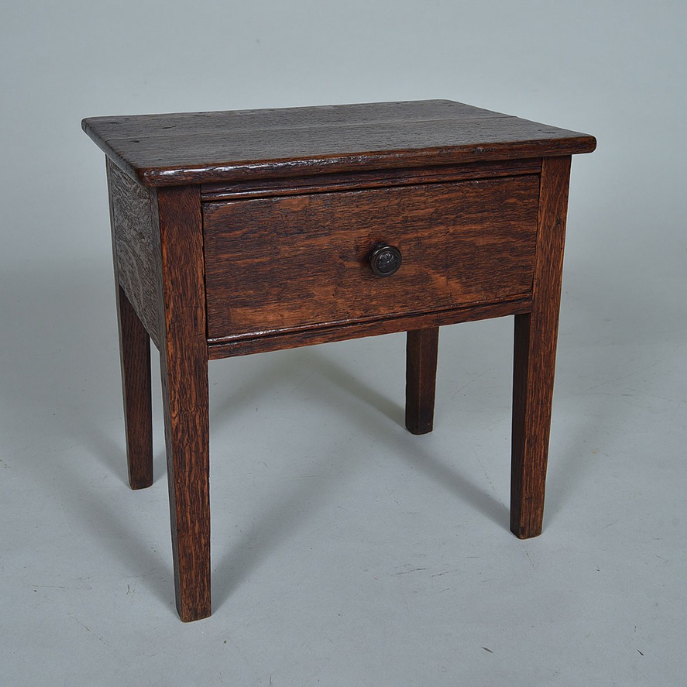 An early 19th-century dark oak side table featuring a single drawer with a turned wood knob and four straight square legs.