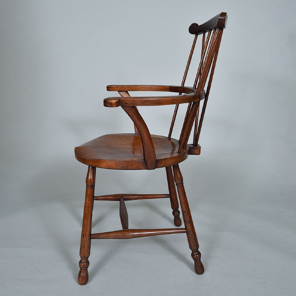 A late 19th-century wooden Windsor armchair featuring vertical spindles, scrolled ears, a contoured saddle seat, and turned legs. View IV