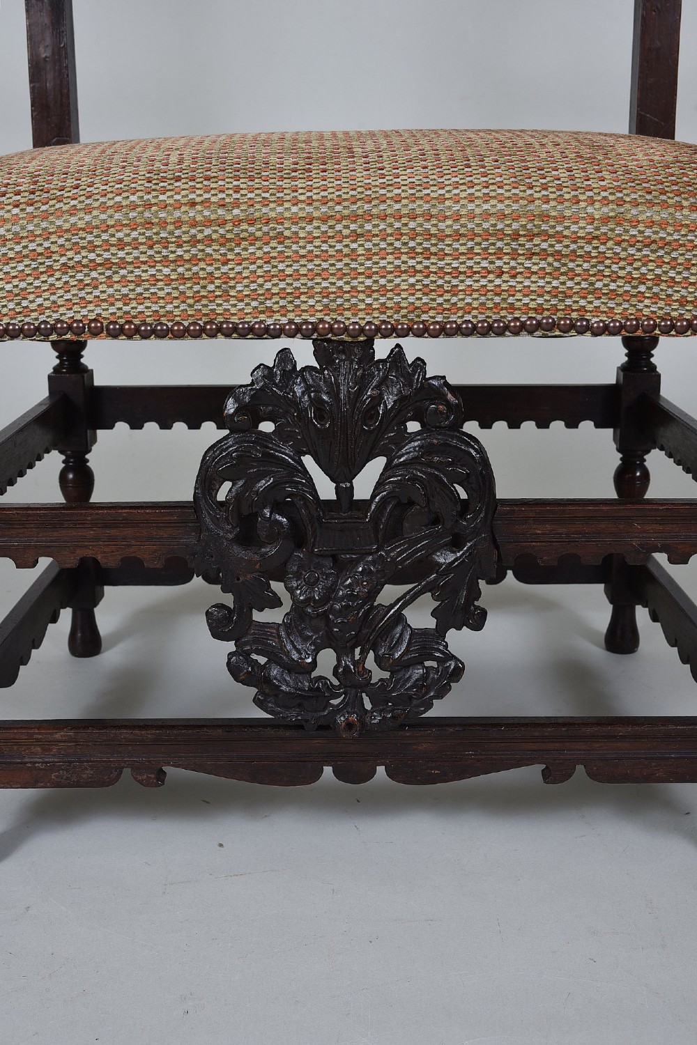 An 18th-century Italian dark walnut armchair featuring intricate openwork foliage carving across the back rails and front stretcher, turned supports, and a patterned woven seat. View II
