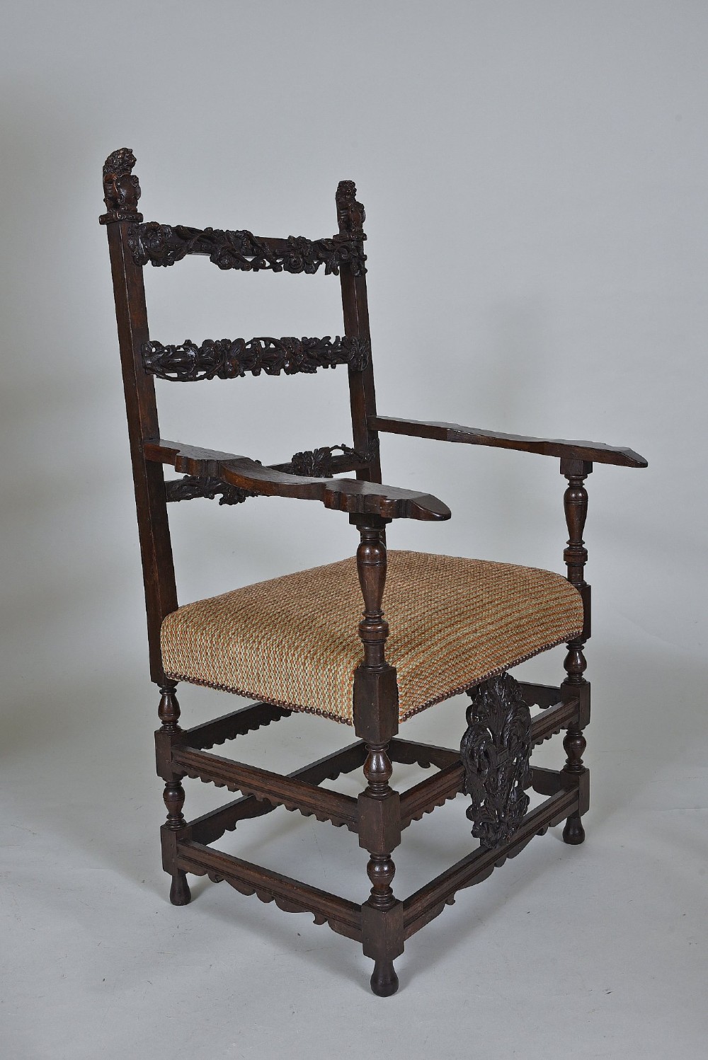 An 18th-century Italian dark walnut armchair featuring intricate openwork foliage carving across the back rails and front stretcher, turned supports, and a patterned woven seat. View III