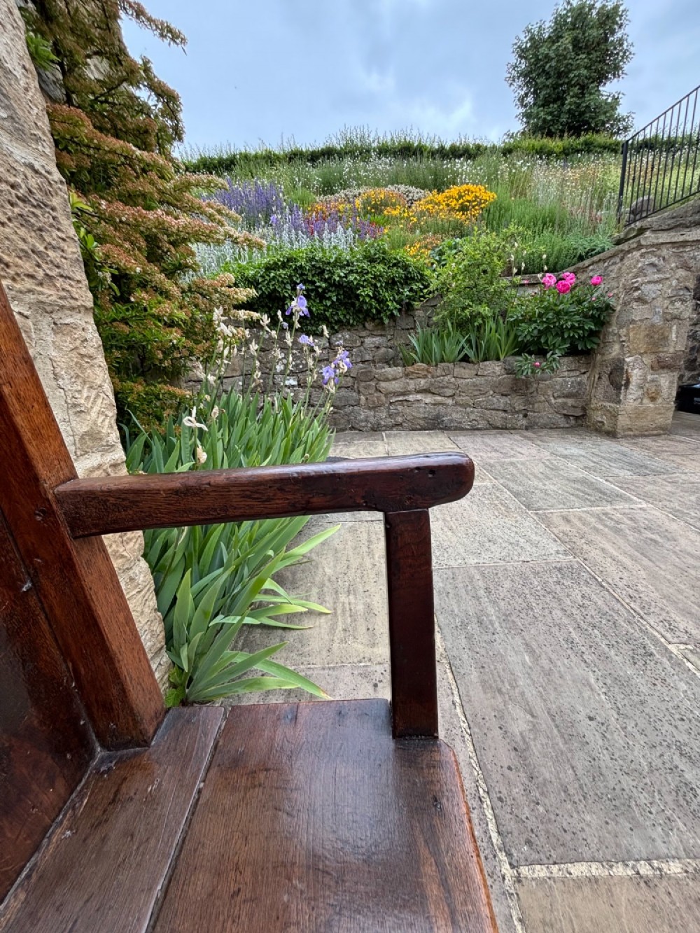 An 18th-century oak settle with a high panelled backrest, flat armrests, and straight legs. View IV