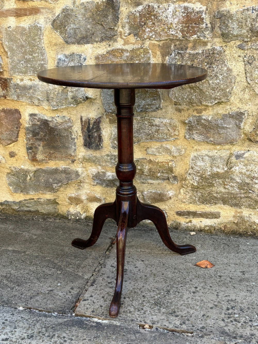 An 18th-century dark oak tripod table featuring a circular top, turned central pedestal stem, and three splayed legs. View IV