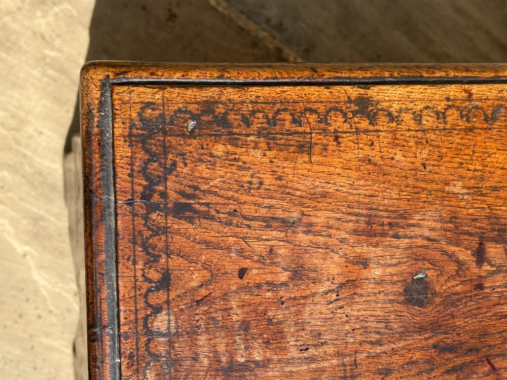 A 17th-century carved oak coffer featuring relief lunette carvings, an iron lockplate, and a dark polished timber finish. View VIII