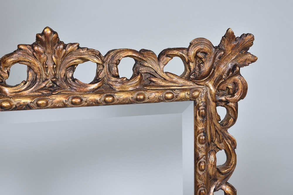 A rectangular nineteenth-century mirror featuring an ornate pierced giltwood frame decorated with carved acanthus leaves and scrollwork. View III
