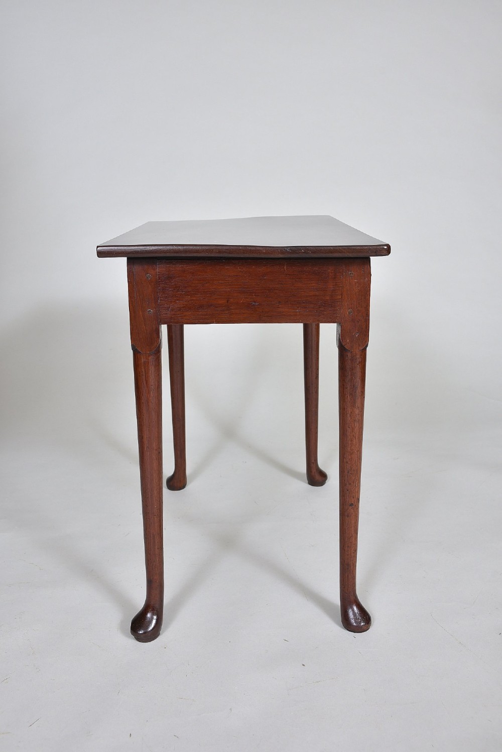 A dark Georgian mahogany side table with a single frieze drawer, brass swan-neck handles, and slender legs ending in pad feet. View IV
