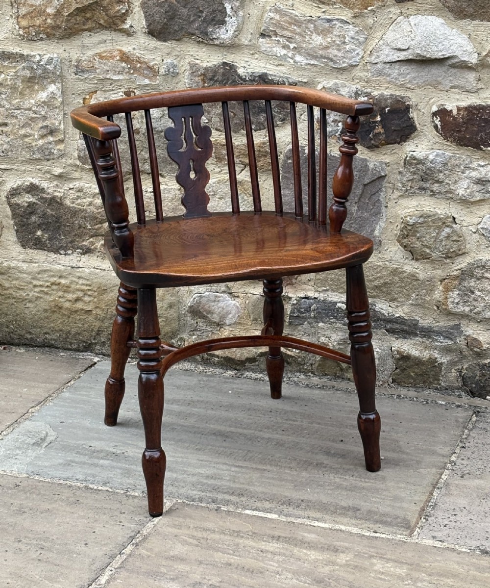 A 19th-century yew wood Windsor armchair featuring a low back rail, turned legs, a shaped seat, and a central pierced back splat flanked by round spindles. View II