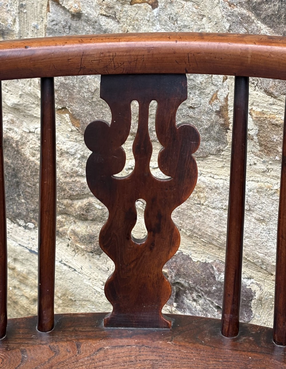 A 19th-century yew wood Windsor armchair featuring a low back rail, turned legs, a shaped seat, and a central pierced back splat flanked by round spindles. View III