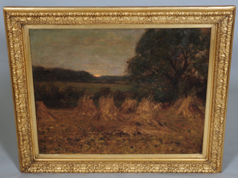 An antique oil painting depicting haystacks in a rural field at dusk, presented in a carved golden giltwood frame.