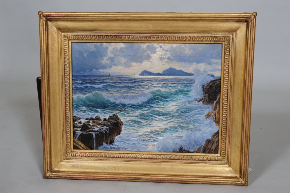 An oil on canvas marine painting depicting crashing turquoise waves against a rocky shoreline under a cloudy sky, presented in a moulded gilded frame.