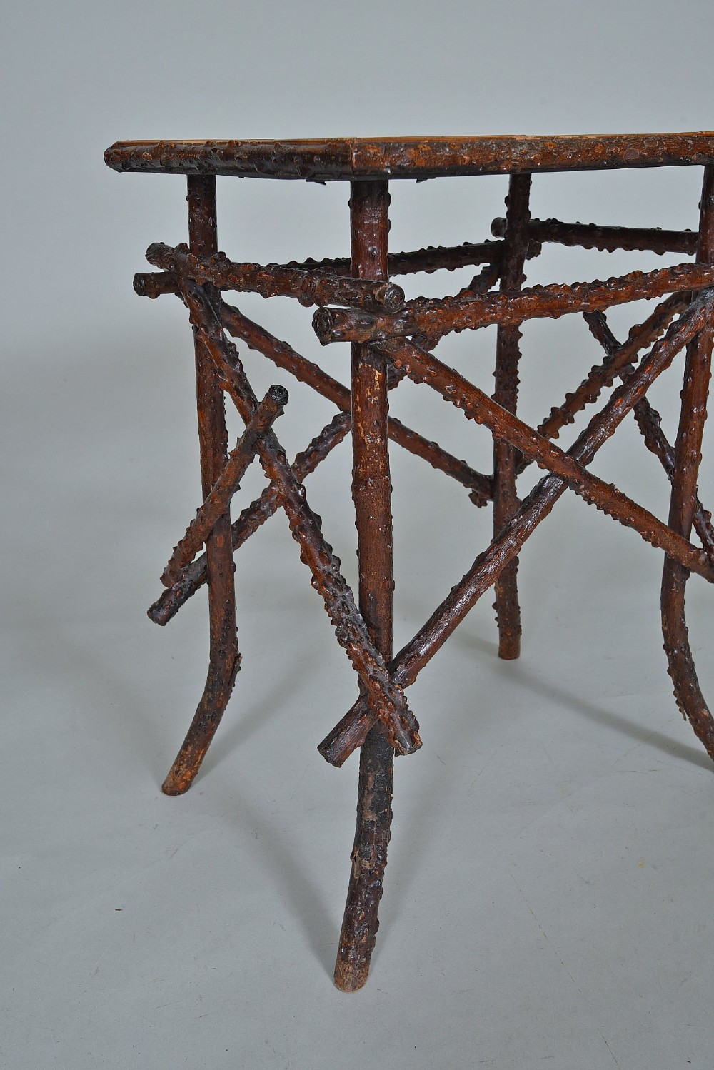 A small rectangular side table constructed from dark brown natural twigs and branches with a smooth lacquered top surface. View II