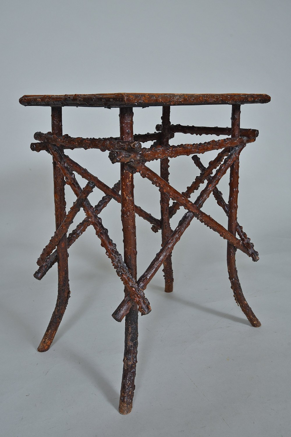 A small rectangular side table constructed from dark brown natural twigs and branches with a smooth lacquered top surface. View V