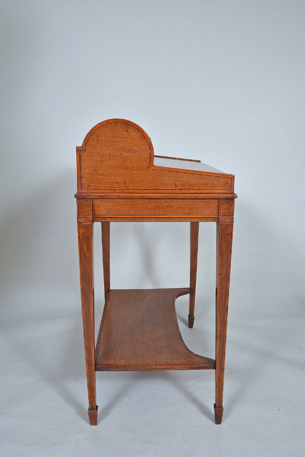 A 19th-century satinwood cylinder bureau featuring an inlaid curved roll-top hood, frieze drawer, square tapered legs, and a shaped lower shelf. View VII
