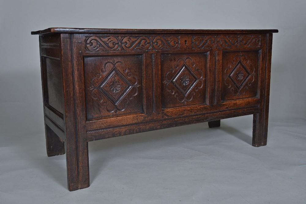 A dark oak seventeenth-century coffer featuring three carved diamond front panels and a carved upper frieze rail. View II