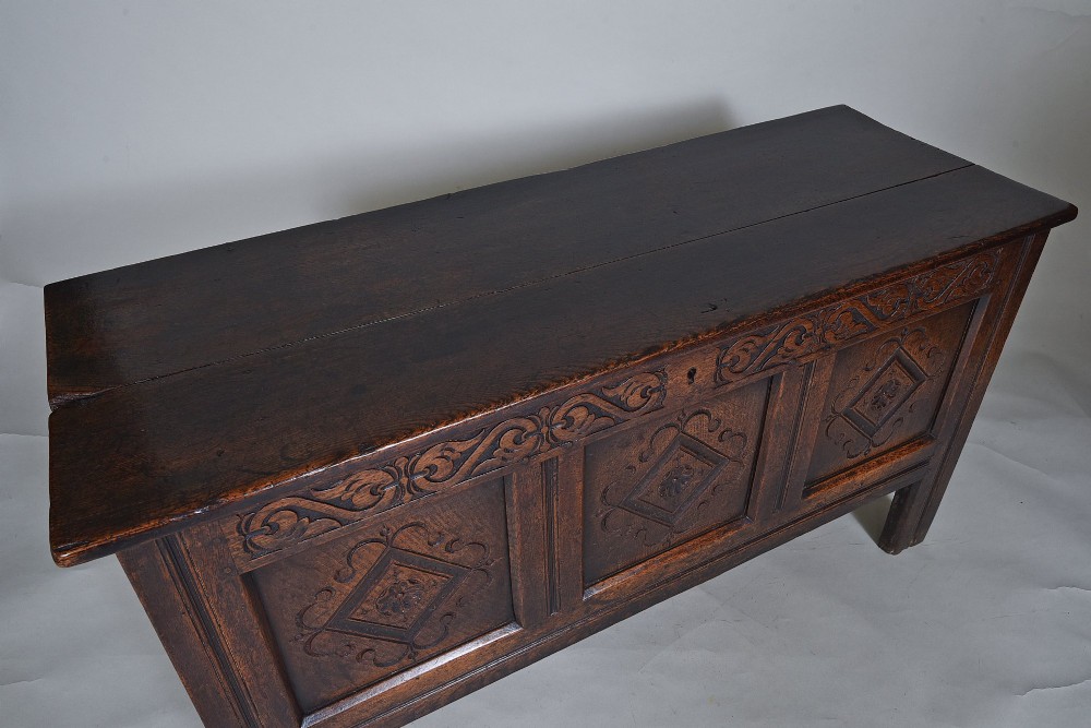 A dark oak seventeenth-century coffer featuring three carved diamond front panels and a carved upper frieze rail. View III