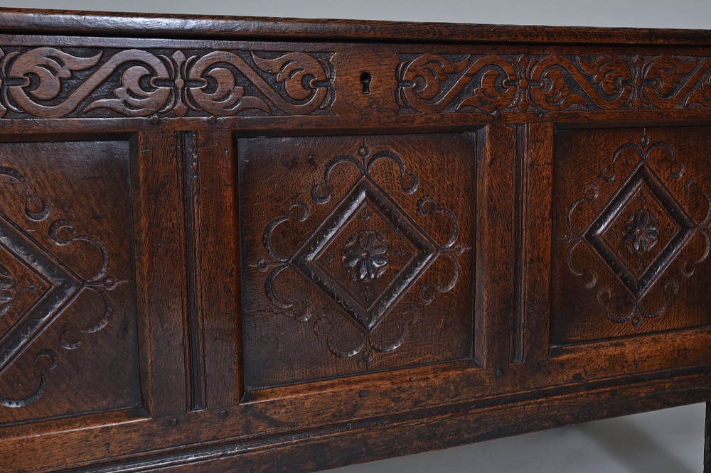 A dark oak seventeenth-century coffer featuring three carved diamond front panels and a carved upper frieze rail. View IV