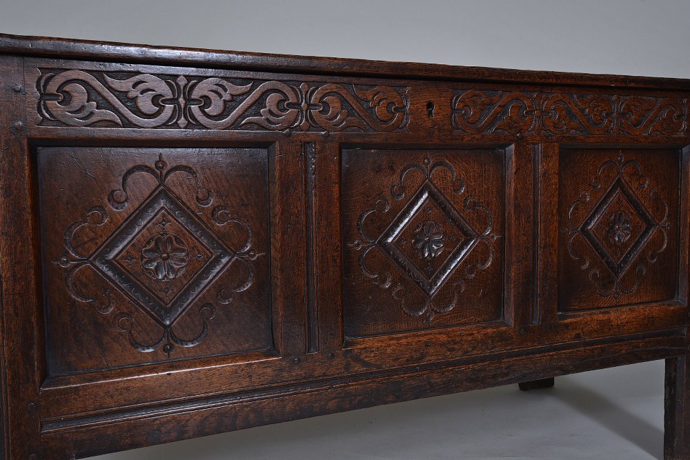 A dark oak seventeenth-century coffer featuring three carved diamond front panels and a carved upper frieze rail. View VI