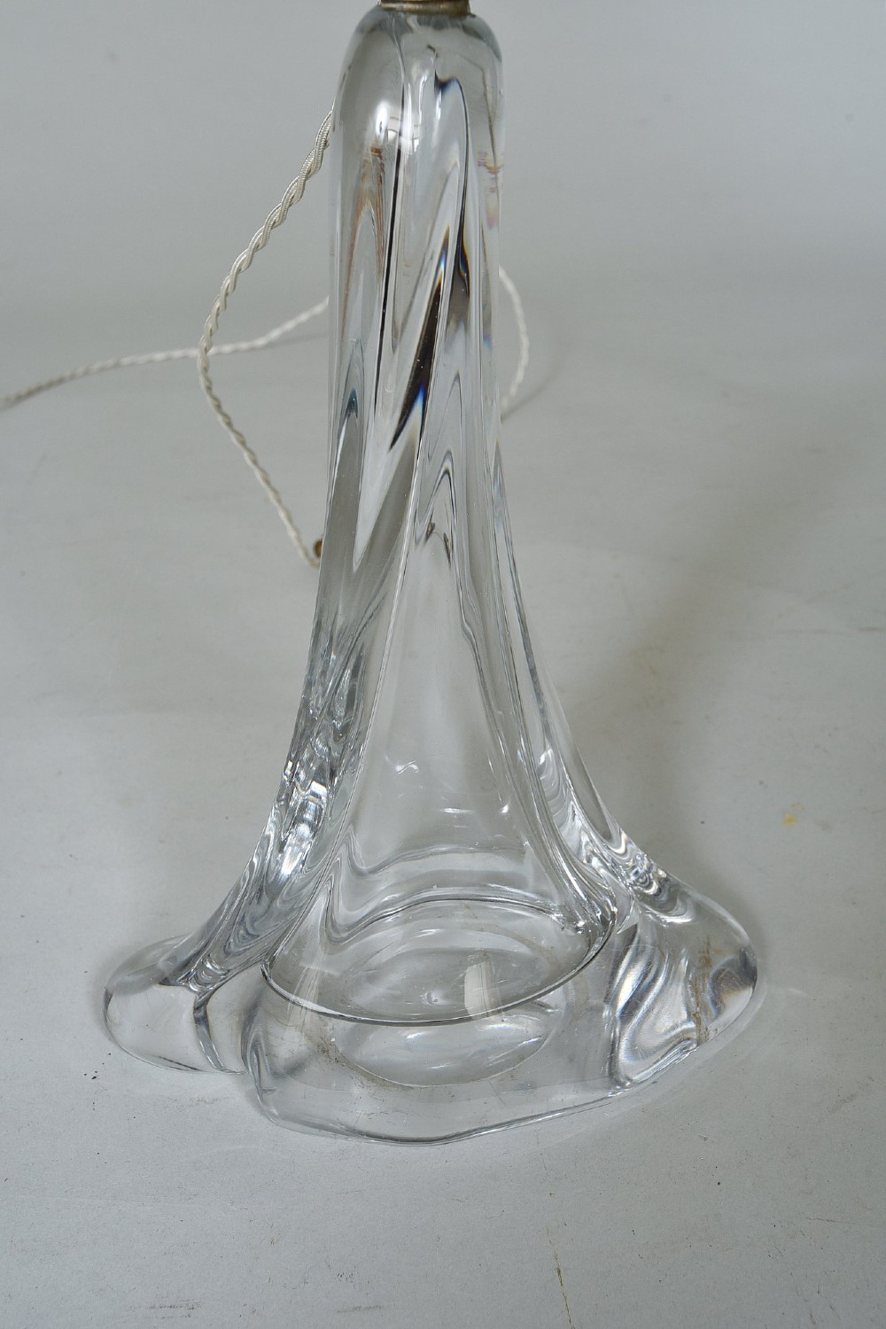 A clear mid-century crystal table lamp base featuring a flared organic form with twisted ribbing and a brass light fitting. View II
