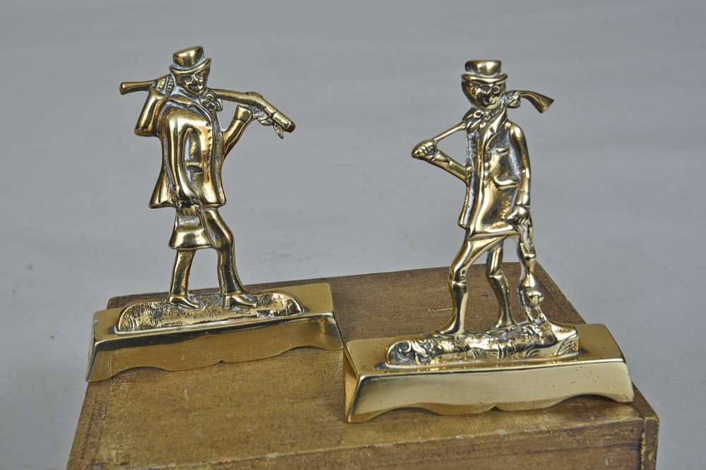 A pair of Victorian cast brass chimney ornaments depicting standing figures with rifles on rectangular plinths.