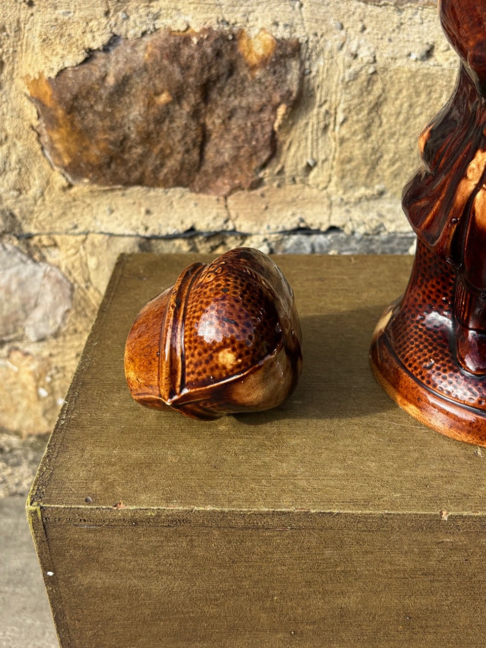A nineteenth-century ceramic Toby jug depicting a seated man wearing a tricorne hat, finished in a rich, mottled treacle-brown glaze. View VIII