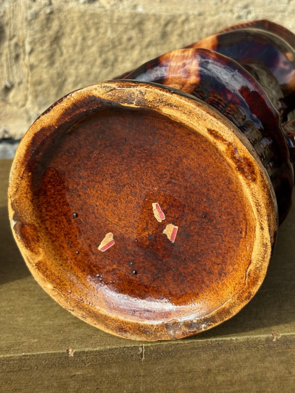 A nineteenth-century ceramic Toby jug depicting a seated man wearing a tricorne hat, finished in a rich, mottled treacle-brown glaze. View XI