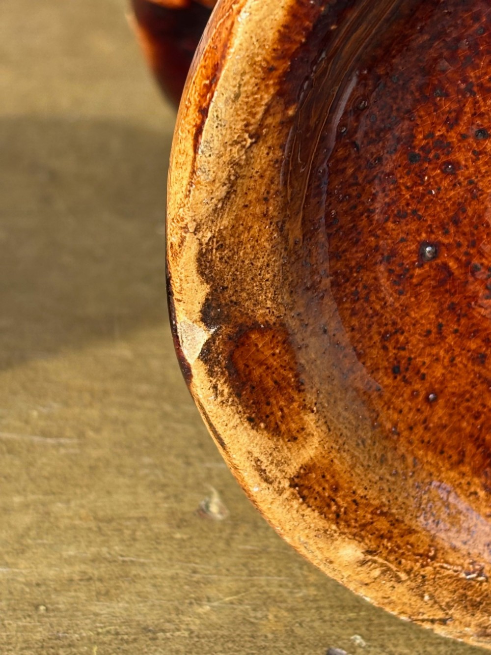 A nineteenth-century ceramic Toby jug depicting a seated man wearing a tricorne hat, finished in a rich, mottled treacle-brown glaze. View XII