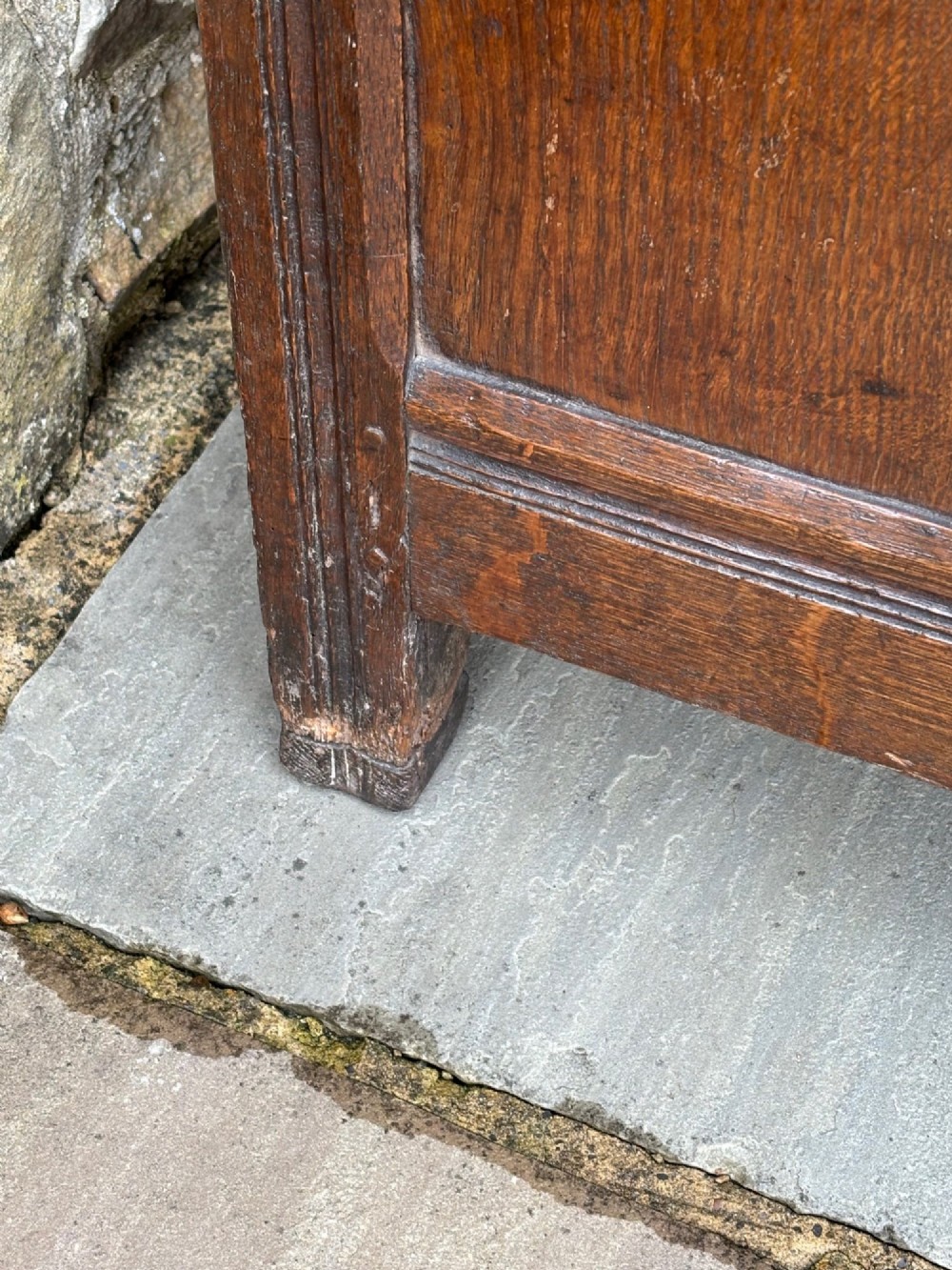A 17th-century oak coffer featuring a hinged lid, panelled front, and geometric marquetry inlay. View VI