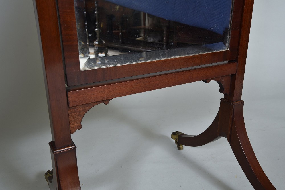 An Edwardian mahogany cheval mirror with an arched frame suspended on upright posts, raised on splayed legs with brass paw castors. View V