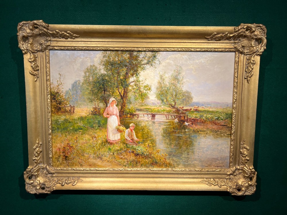 A 19th-century oil painting depicting a woman and a boy by a riverbank in an ornate gold gilt frame.