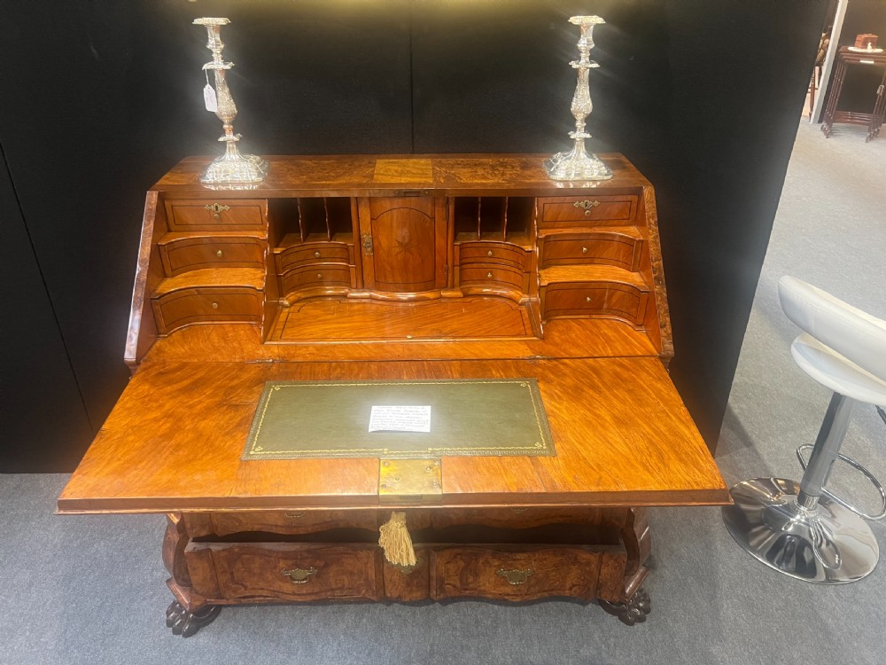 An antique burr walnut slant-front writing bureau featuring serpentine front drawers, brass escutcheons, and carved feet. View II
