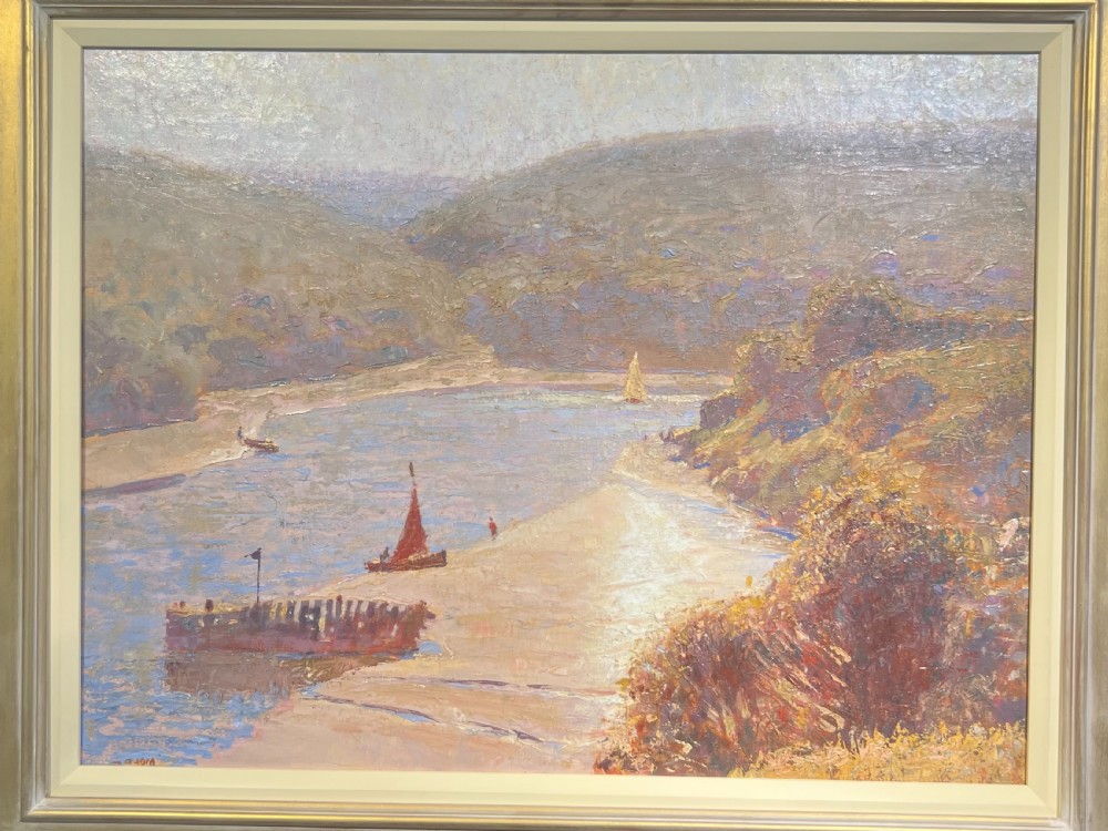 An impressionist landscape oil painting in a light metallic frame depicting a river estuary with sailboats and surrounding hills.