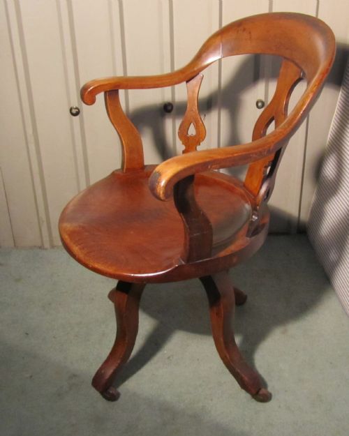 A Swiveling Elm and Mahogany Office Chair or Desk Chair on Casters