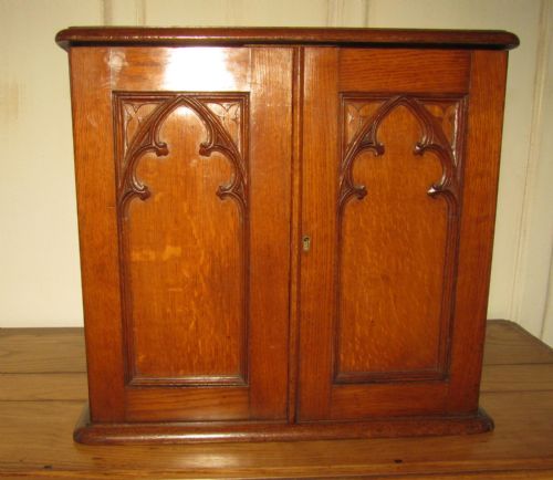 A Victorian Arts and Crafts Gothic Revival Oak Collectors Cabinet