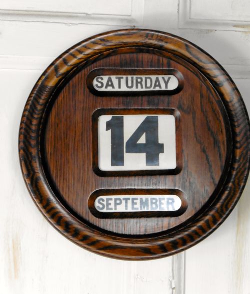 An Art Deco Round Oak Perpetual Wall Calendar