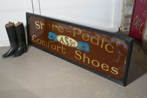 fig 1. A wide rectangular black-framed commercial glass sign with gold leaf text reading Shore-Pedic Comfort Shoes on a dark brown background.