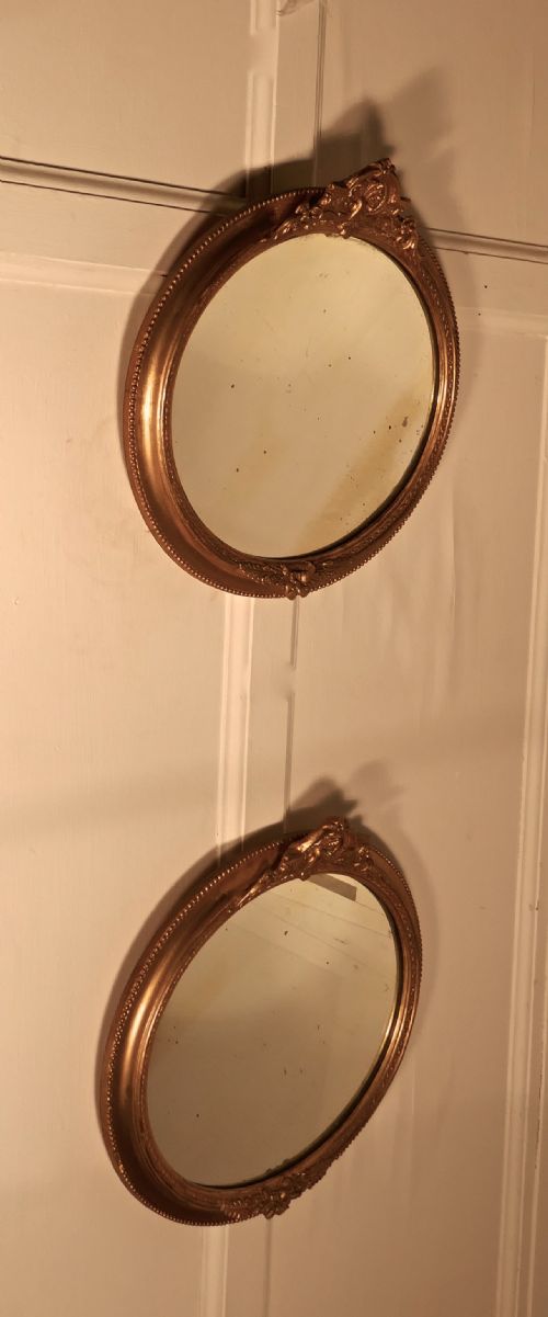 A Rare Pair of 19th Century Regency Style Oval Gilt Mirrors