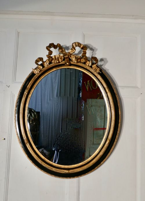 fig 1. A Large French Ebonised and Gilt Oval Wall Mirror