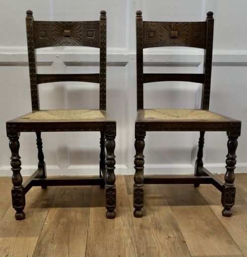A Pair of Arts and Crafts Gothic Carved Oak Hall Chairs