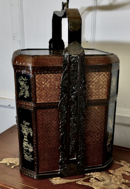 fig 1. An octagonal Chinese wedding basket constructed from woven bamboo and dark lacquered wood with a tall overhead handle and double doors at the base.