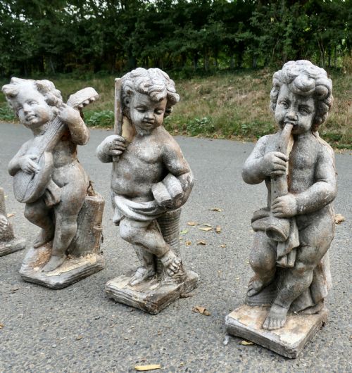 A SET OF 4 WEATHER WORN CHERUB STATUES WITH INSTRUMENTS - ADDITIONAL PHOTO 4