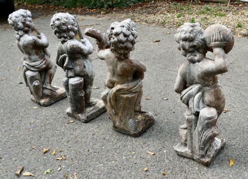 A SET OF 4 WEATHER WORN CHERUB STATUES WITH INSTRUMENTS - ADDITIONAL PHOTO 2