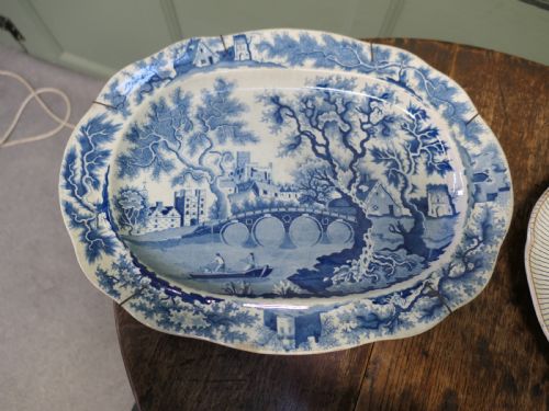 fig 1. Pair of early nineteenth-century oval earthenware chargers featuring blue and white printed landscape and maritime motifs.