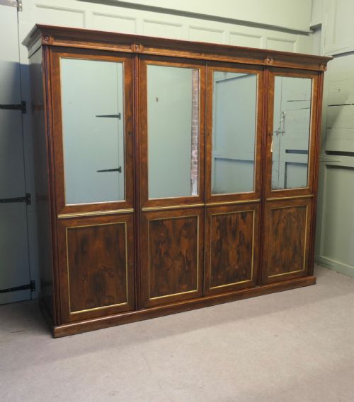 fig 1. A nineteenth-century Regency rosewood four-door wardrobe with mirrored upper sections and brass stringing decoration.