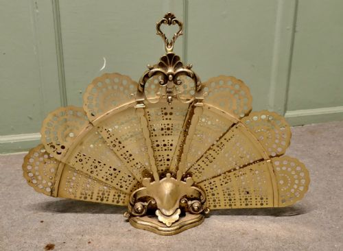 fig 1. A French cast brass folding fire screen in the shape of a peacock tail with reticulated filigree blades and an ornate Rococo base.