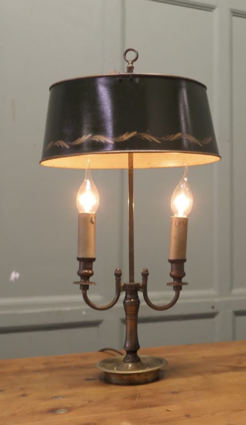 fig 1. A French twin-light bouillotte desk lamp featuring a dark green painted metal shade with gilt foliate decoration and a brass stem with a dished base.