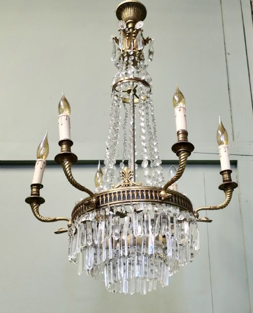 fig 1. A French Empire style six-branch chandelier featuring a crystal bead tent structure, central brass band with outward-extending scroll arms, and cascading crystal waterfall drops.